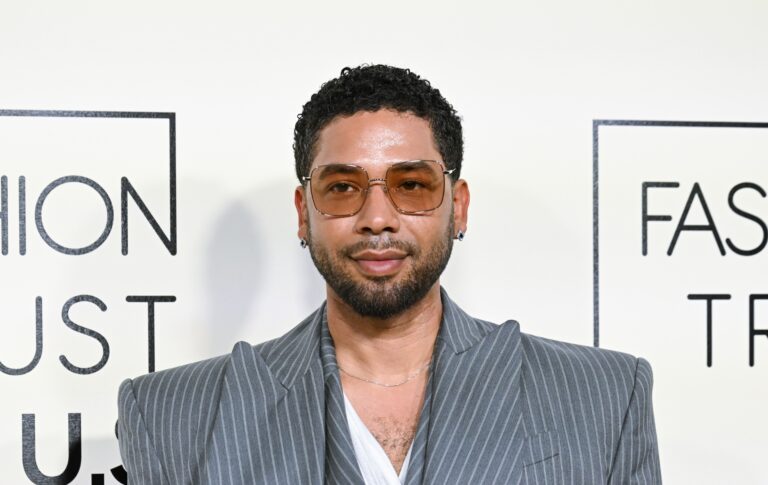 Jussie Smollett in a grey pinstruoe suit. He