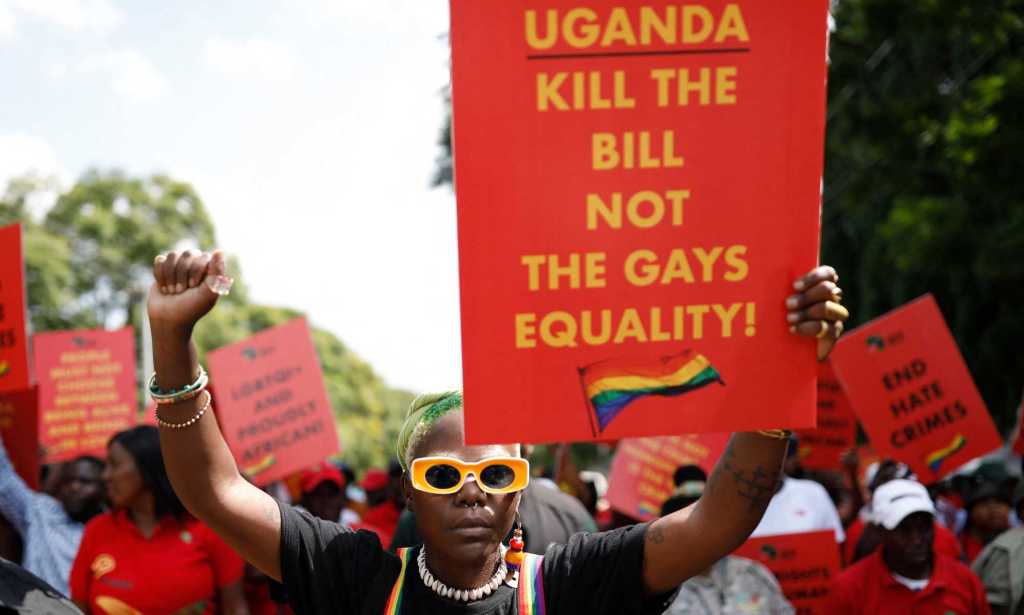 Delogie Kwagala représenté tenant une pancarte qui dit "L'Ouganda tue le projet de loi et non l'égalité des gays!".