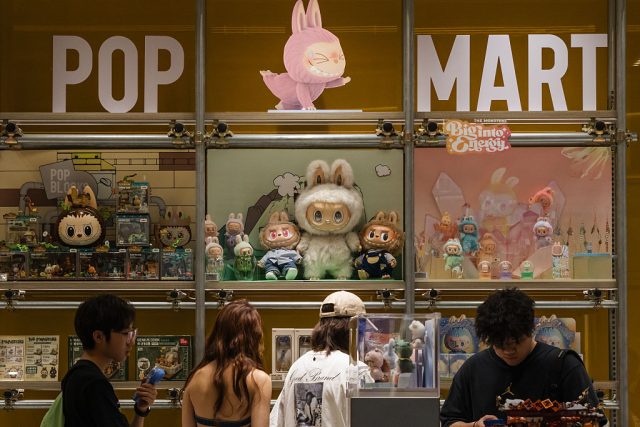 Les clients parcourent un écran Pop Mart rempli de personnages de Labubu et de chiffres de collection de la série Monsters le 16 juin 2025 à Chongqing, en Chine. L'IP Labubu a augmenté en popularité entre la génération Z de la Chine, avec des gouttes en édition limitée, des produits co-marqués et des expériences de vitrines immersives transformant les jouets de créateurs en un phénomène culturel grand public.