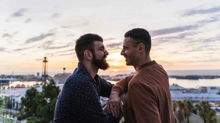 Les meilleures villes de croisière gay du monde ont révélé – y compris deux villes britanniques Gay couple on lookout above the city with view to the port, Barcelona, Spain.