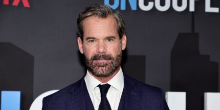 Tuc Watkins in a blue suit white shirt black tie.