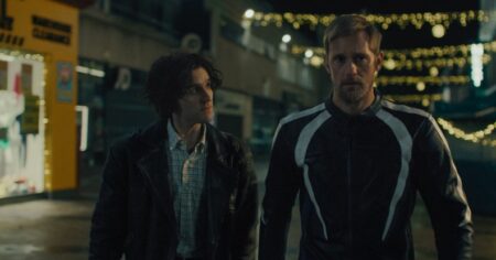 PILLION STAUDE: Harry Melling et Alexander Skarsgård marchant ensemble la nuit.
