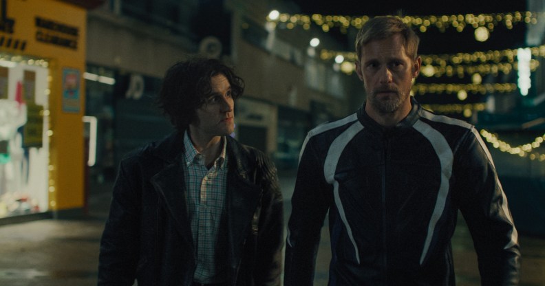 PILLION STAUDE: Harry Melling et Alexander Skarsgård marchant ensemble la nuit.