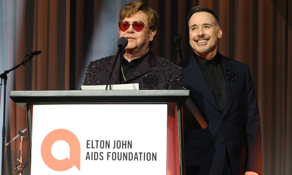 Elton John avec David meuble parlant sur un podium Elton John AIDS Foundation.