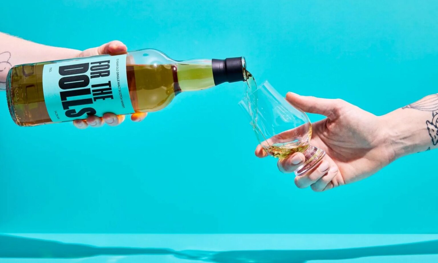 Le whisky « For the Dolls » combat la transphobie en soutenant une association caritative trans An unpictured person pouring a bottle of the For the Dolls whisky.