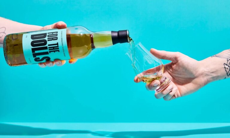 An unpictured person pouring a bottle of the For the Dolls whisky.