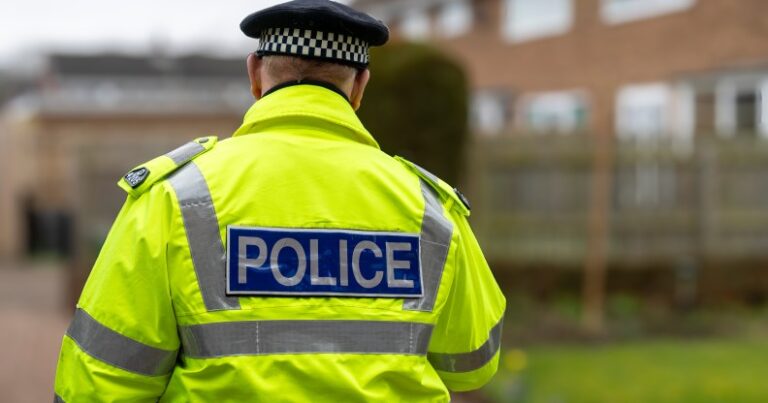 Un homme arrêté après avoir prétendument affiché une pancarte homophobe lors d'une manifestation anti-immigration Un policier s'éloigne.