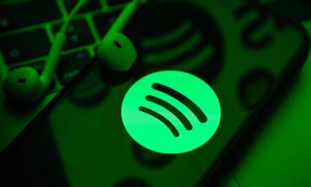 A phone in a green light with the Spotify symbol.