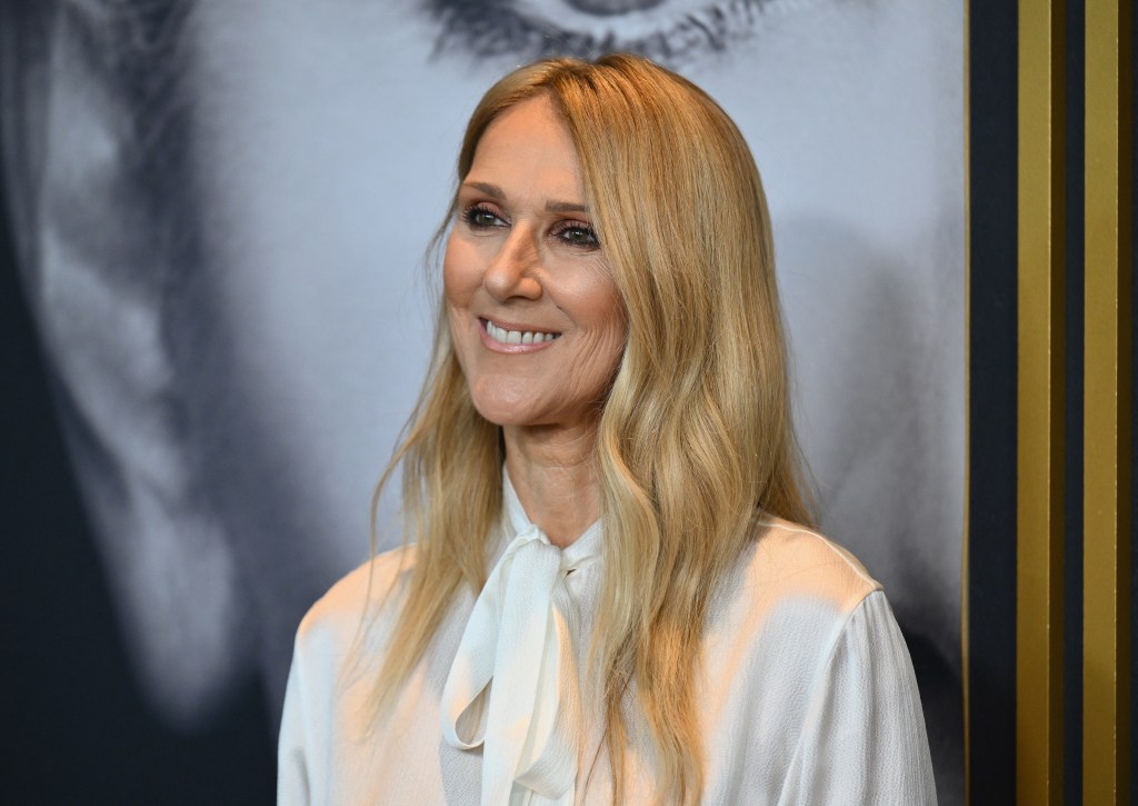 Céline Dion souriante dans une chemise blanche