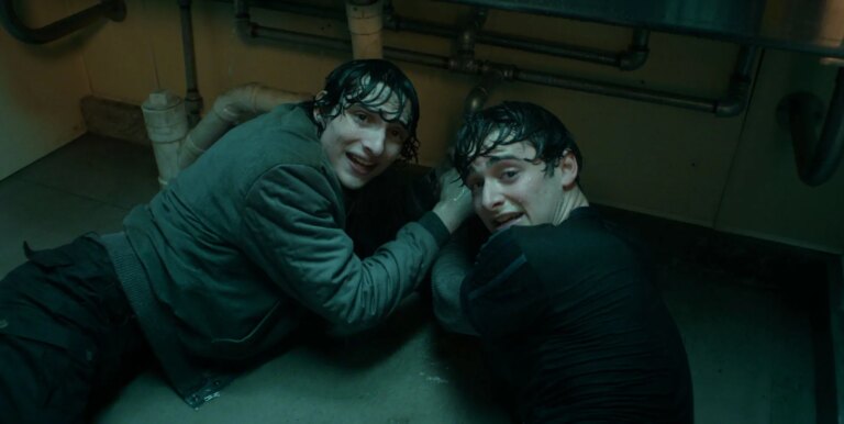 Noah Schnapp aborde l'expédition de « Byler » et fait tourner les fans de Stranger Things Finn Wolfhard and Noah Schnapp on a bathroom floor in Stranger Things season five.