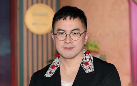 Bowen Yang in a black suit with an embroided collar, white and red detailing