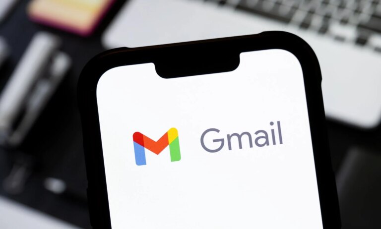 Les personnes trans pourraient supprimer le « nom mort » de l'adresse Gmail grâce à de nouveaux changements Someone holding a phone in front of a laptop with the Gmail logo visible.