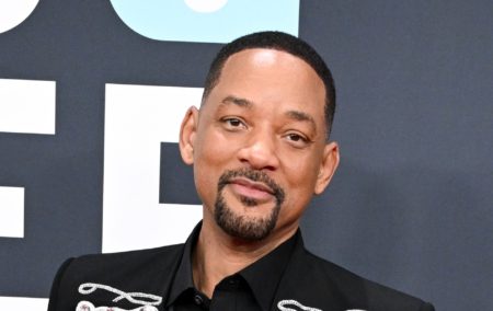 Will Smith at the 67th GRAMMY Awards. Wearing a black suit against a grey backgrop