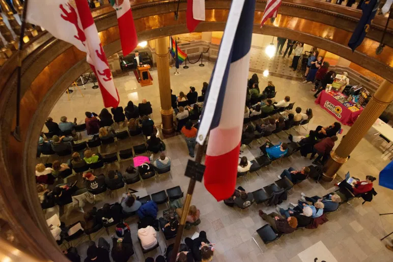 Une foule d'environ 100 défenseurs LGBTQ+ écoutent les orateurs lors de l'événement de la Journée de l'égalité au Kansas Statehouse le 20 janvier 2026.