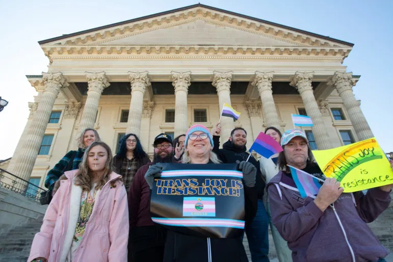 Des défenseurs LGBTQ+ tiennent des pancartes à l'extérieur après l'événement de la Journée de l'égalité au Kansas Statehouse le 20 janvier 2026.