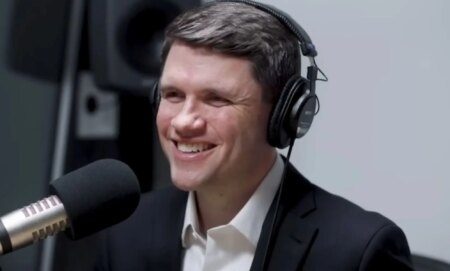 James Talarico, pictured in a recording booth with headphones on.