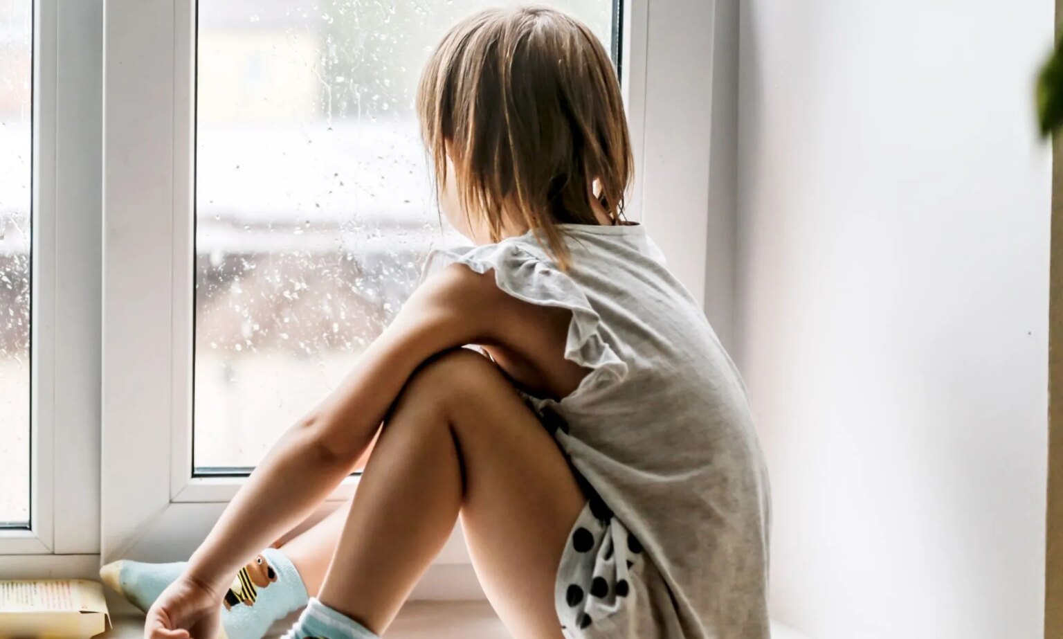 Les bloqueurs de puberté sont désormais totalement inaccessibles aux jeunes trans après la pause de l’essai du NHS A child sat looking out of a window.