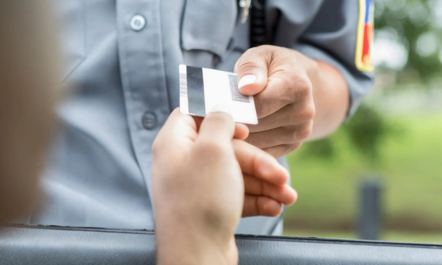 Le Kansas menace d'emprisonner les personnes trans qui ne rendent pas leur carte d'identité A person handing an officer their license.