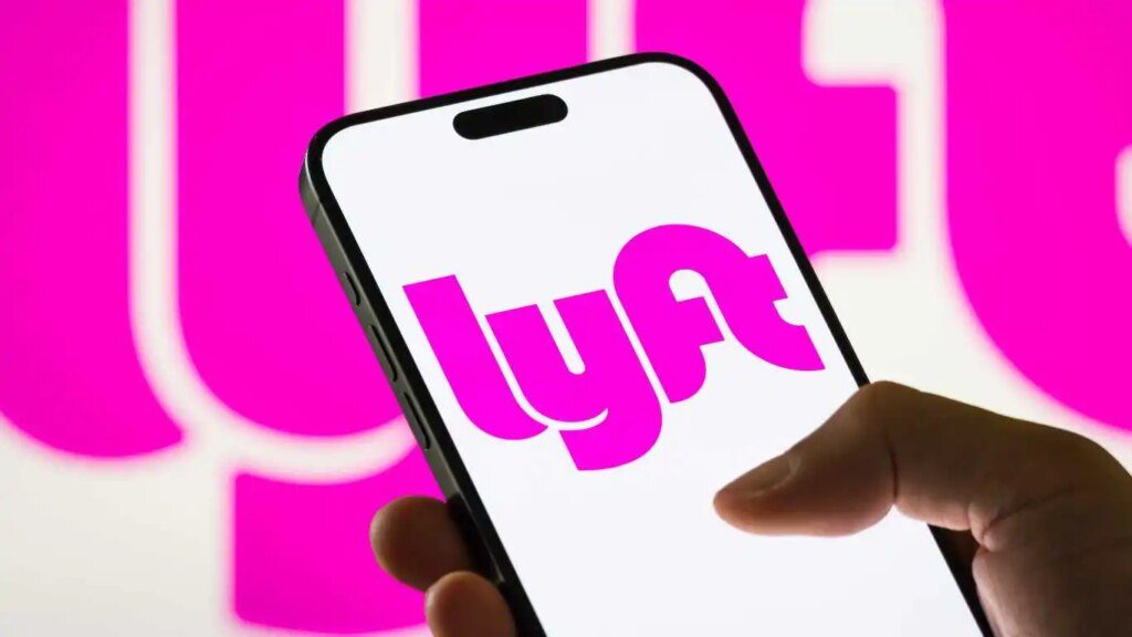 Lyft propose des trajets aux résidents trans du Kansas alors que les permis de conduire sont annulés In this photo illustration, a smartphone displays the logo of Lyft Inc. (NASDAQ: LYFT), a major American ride-sharing company, with a blurred version of the company