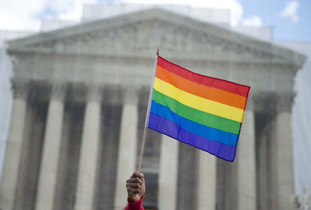 Un partisan du mariage homosexuel brandit un drapeau arc-en-ciel devant la Cour suprême des États-Unis.