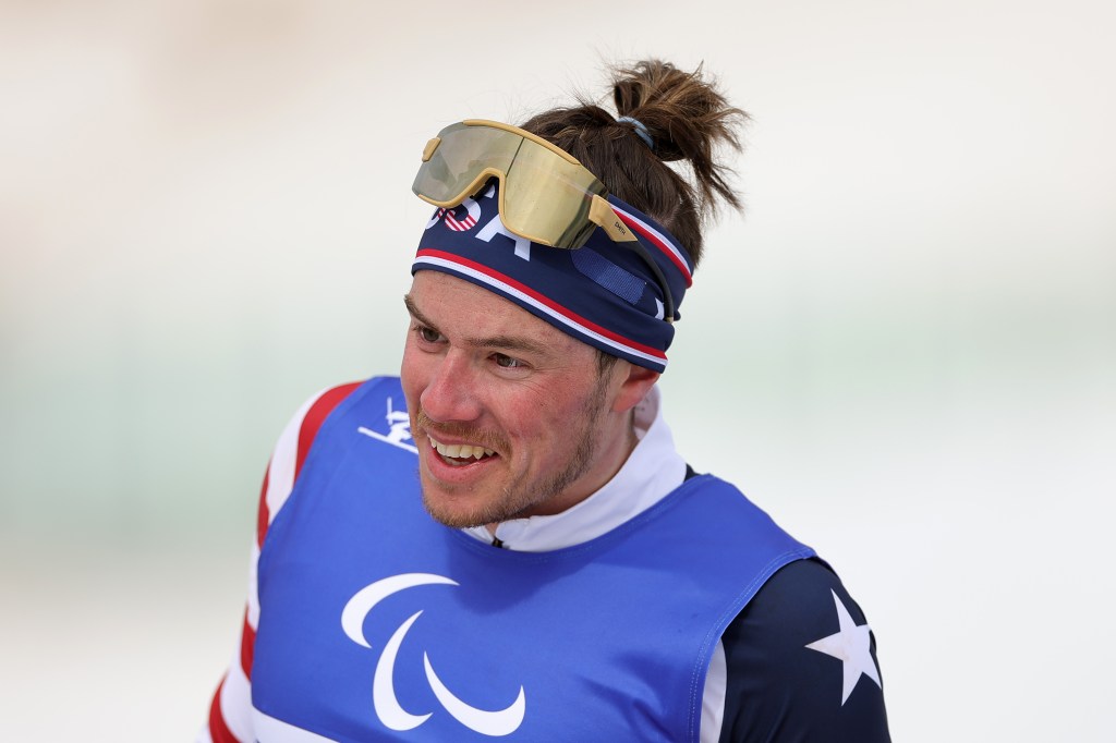 Jake Adicoff de l'équipe de patinage des États-Unis, il porte l'équipement de l'équipe américaine avec ses lunettes relevées.