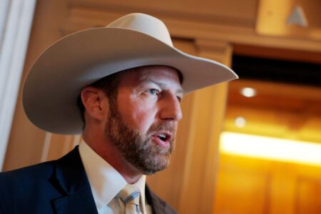 Markwayne Mullin, a white man with a beard, wearing a cowboy hat