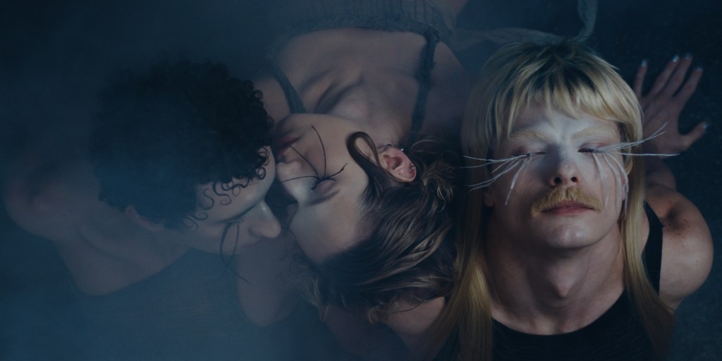 Danser, c'est encore résister : trois danseurs maquillés et aux cils extrêmement longs reposant la tête l'une contre l'autre.