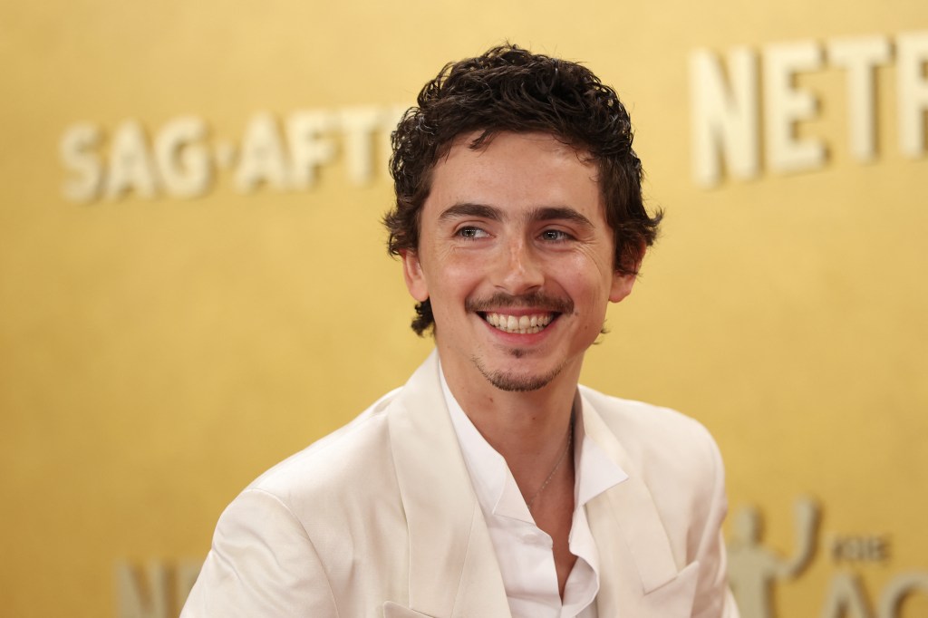 Portrait de Timothée Chalamet, vêtu d'un complet costume blanc