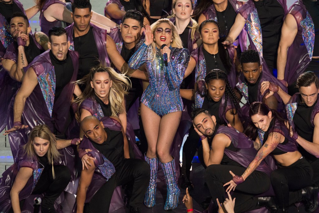 Lady Gaga se produit pendant le Halftime Show, vêtue d'un body violet scintillant, entourée de danseurs.