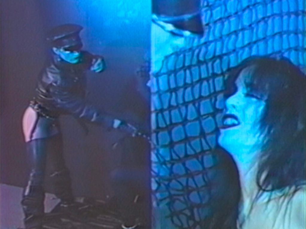 Mixtape lesbienne pixélisée : image fixe de Wicked Times d'Azian Nurudin : une personne avec un fouet en arrière-plan avec une femme au premier plan.