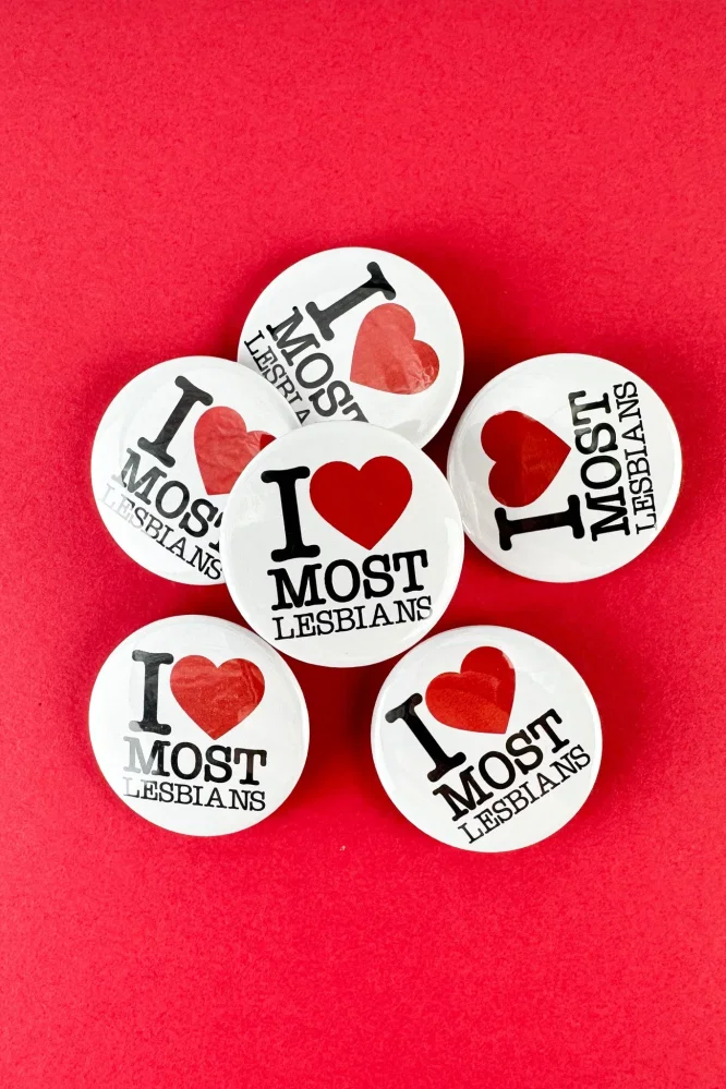 un groupe de boutons qui disent que j'aime la plupart des lesbiennes sur fond rouge