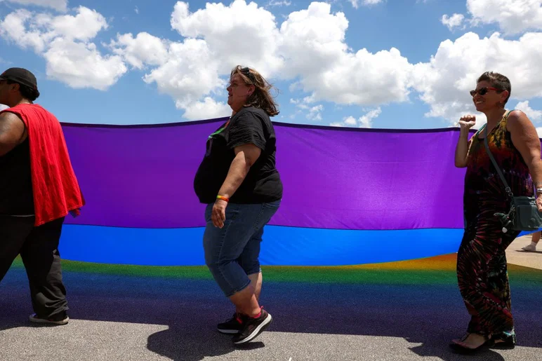 Les gens portent un grand drapeau arc-en-ciel lors du défilé lors du cinquième festival annuel de la Treasure Coast Pride Fest, le 25 avril 2026, au parc des expositions du comté de St. Lucie. L'événement était organisé par Sanctuary of the Treasure Coast.