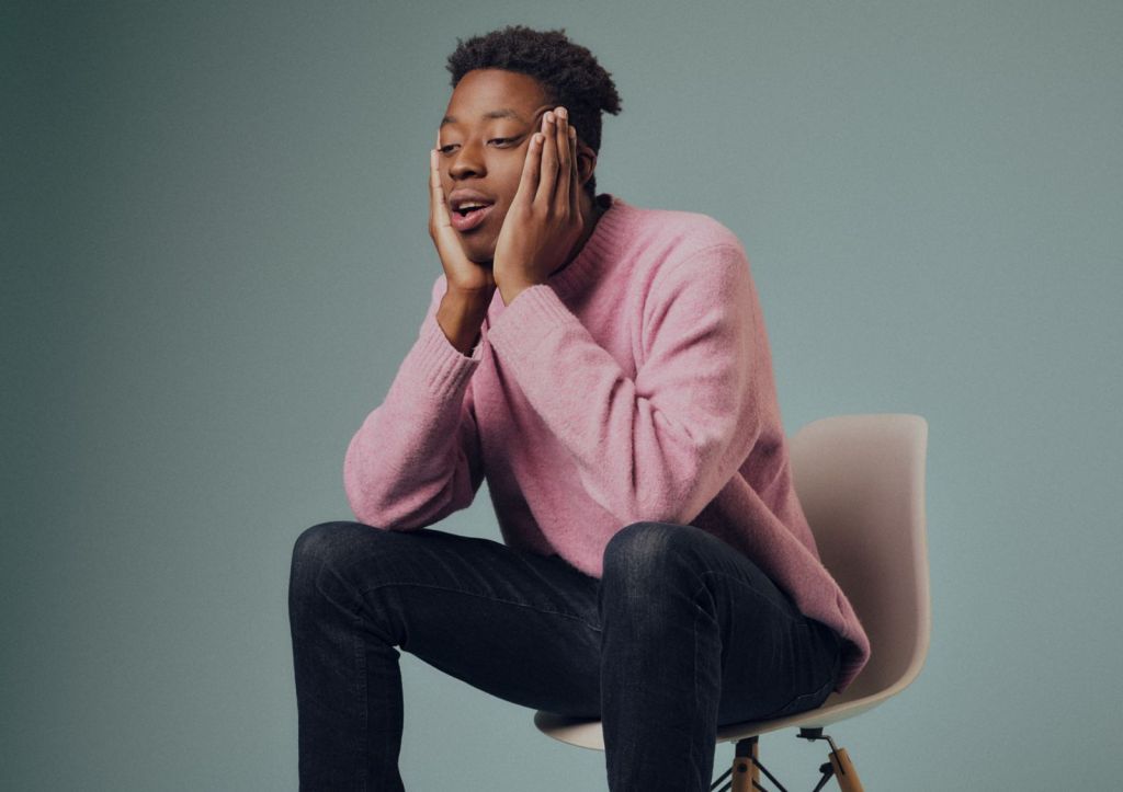 Ayo Adenekan : Insécurité intérieure. Ayo dans un pull rose était assise sur une petite chaise