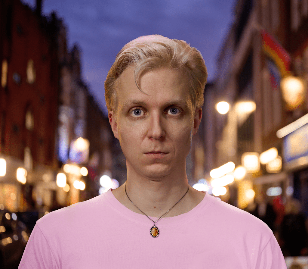 Linus Karp a été frappé avec un parapluie : un homme vêtu d'un t-shirt rose dans une rue regardant la caméra.