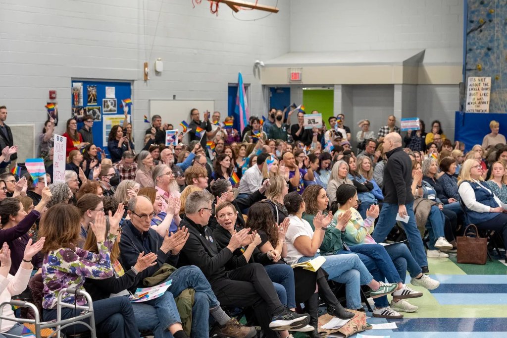 Des centaines de membres de la communauté et de partisans des droits des trans applaudissent et applaudissent lors d'une réunion du conseil d'administration du district 109 de Deerfield à la Caruso Middle School de Deerfield, en Illinois, le 10 avril 2025. Photo de Tyler Pasciak LaRiviere pour le Chicago Sun-Times.