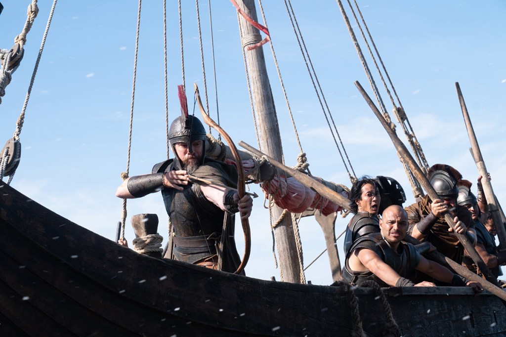 L'Odyssée : Matt Damon tirant avec un arc et des flèches depuis un navire