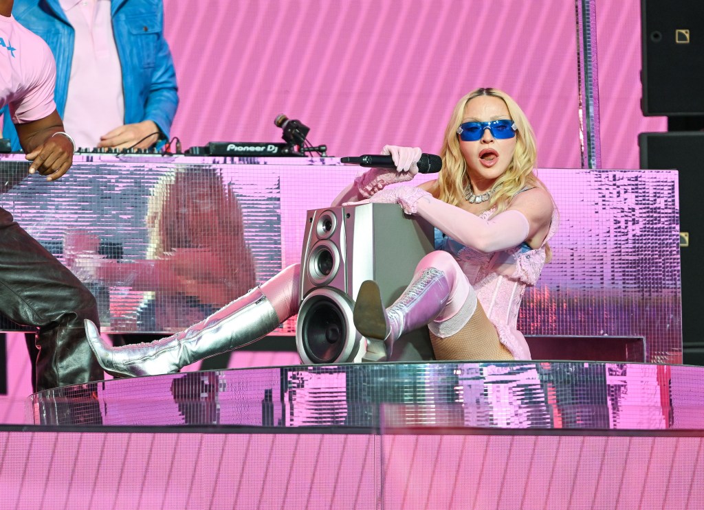 Madonna assise avec un haut-parleur entre ses jambes lors d'un concert