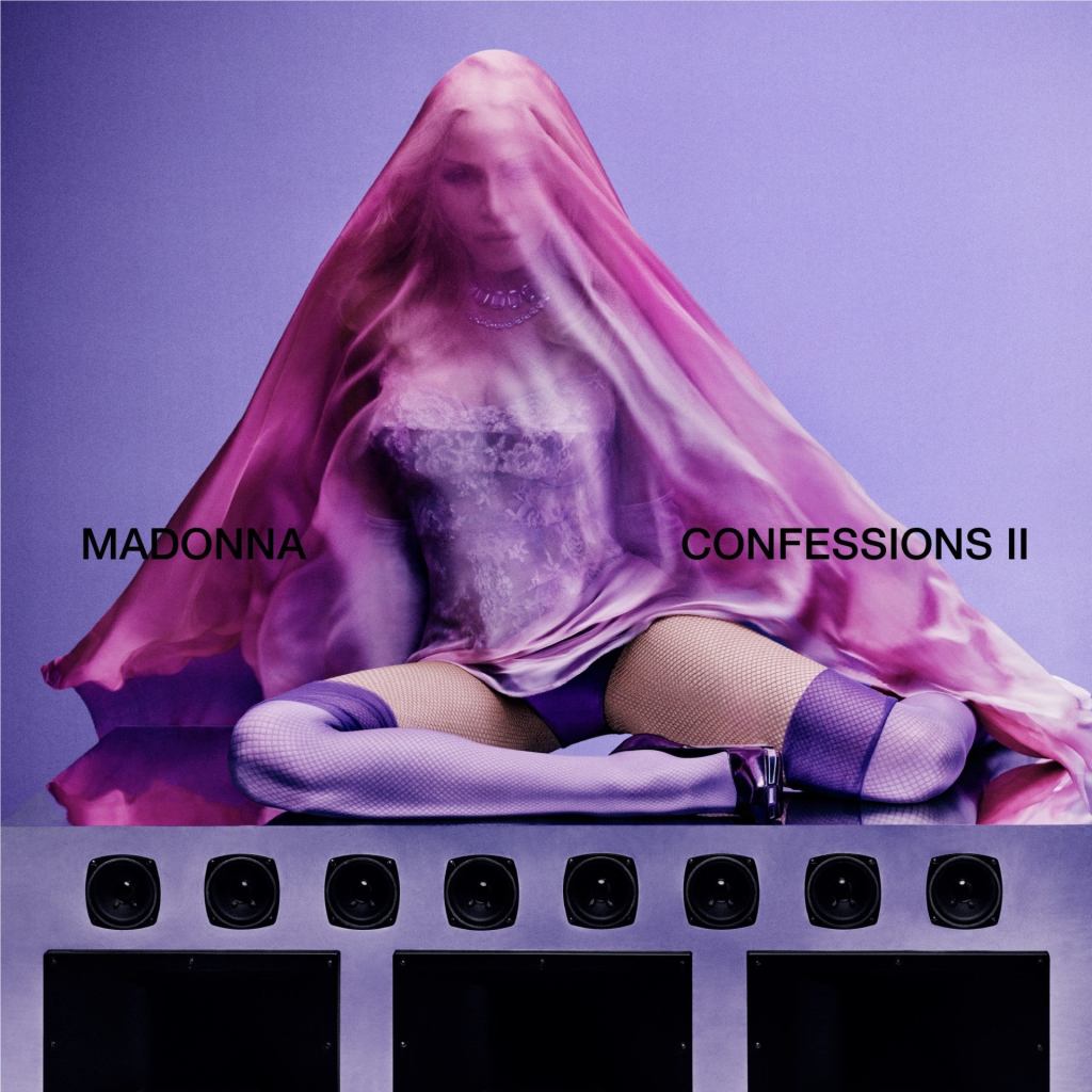 Madonna's Confessions II est maintenant disponible. La pochette de l'album de Madonna était assise au sommet d'un haut-parleur, vêtue de collants violets et d'un corset recouvert d'un foulard en soie rose transparent.