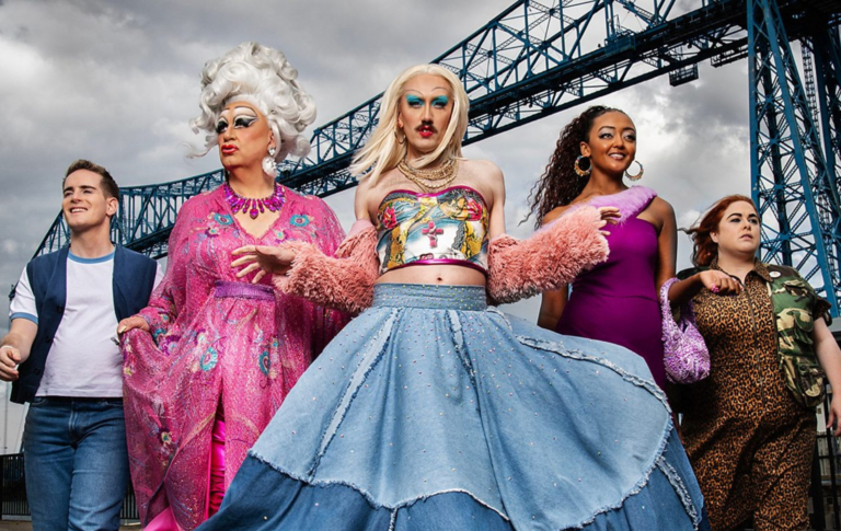 La sitcom LGBTQ+ Smoggie Queens de retour pour la série 3 : « J'ai hâte de voir le chaos » Smoggie Queens still, five individuals walking against a grey cloudy sky