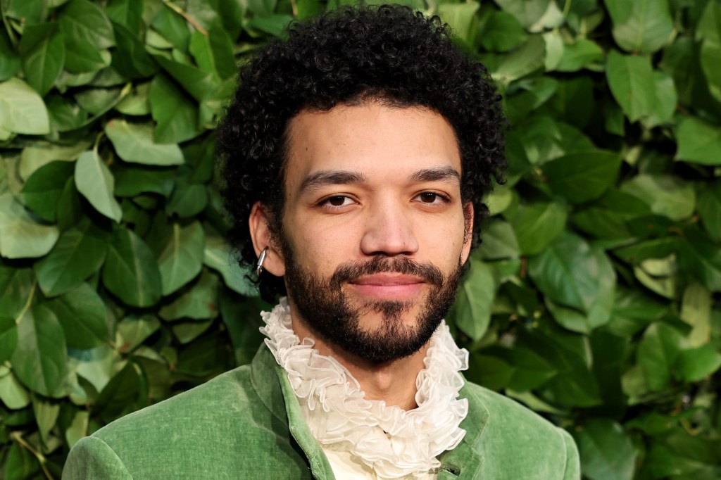 Le juge Smith dans un costume vert avec une chemise à col volanté