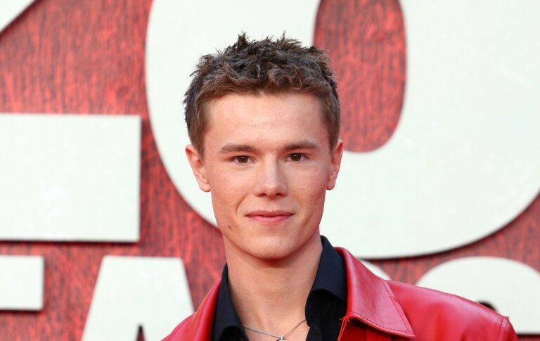 Apprenez à connaître Edvin Ryding, de la deuxième saison de Young Royals à Heated Rivalry Edvin Ryding on a red carpet, wearing a black shirt and red leather jacket