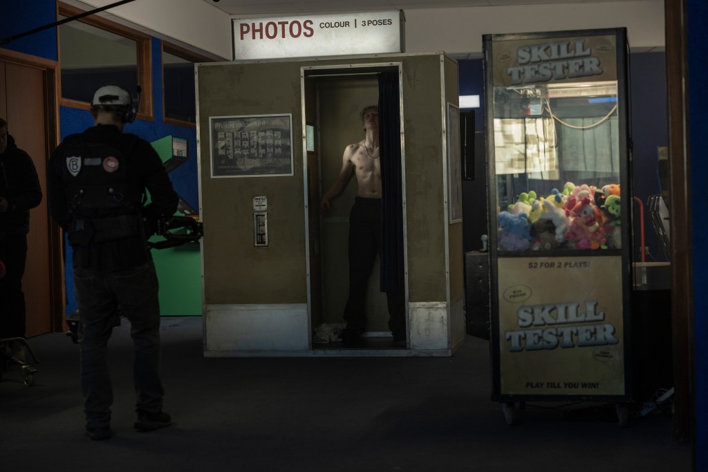 Ryan (Stacy Claisen) dans un photobooth, torse nu