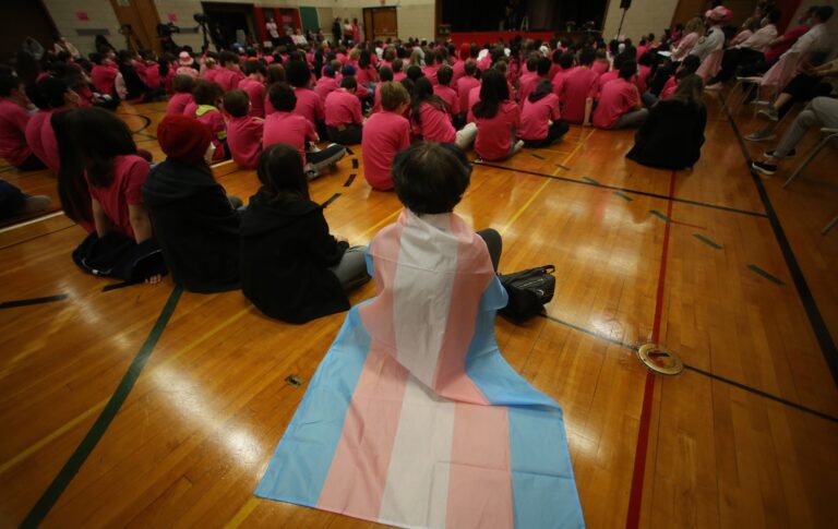 Le procureur général de Donald Trump affirme que des « transitions secrètes entre les sexes dans les écoles » ont lieu, sans aucune preuve. A student wears a trans flag during an assembly