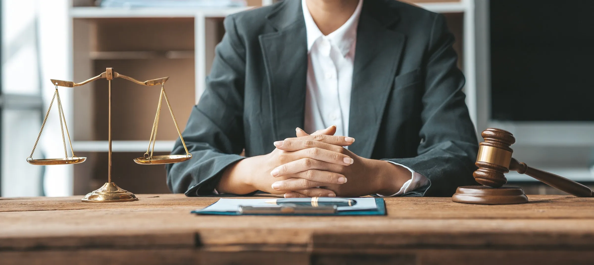 Personne assise à un bureau avec une balance de justice et un marteau