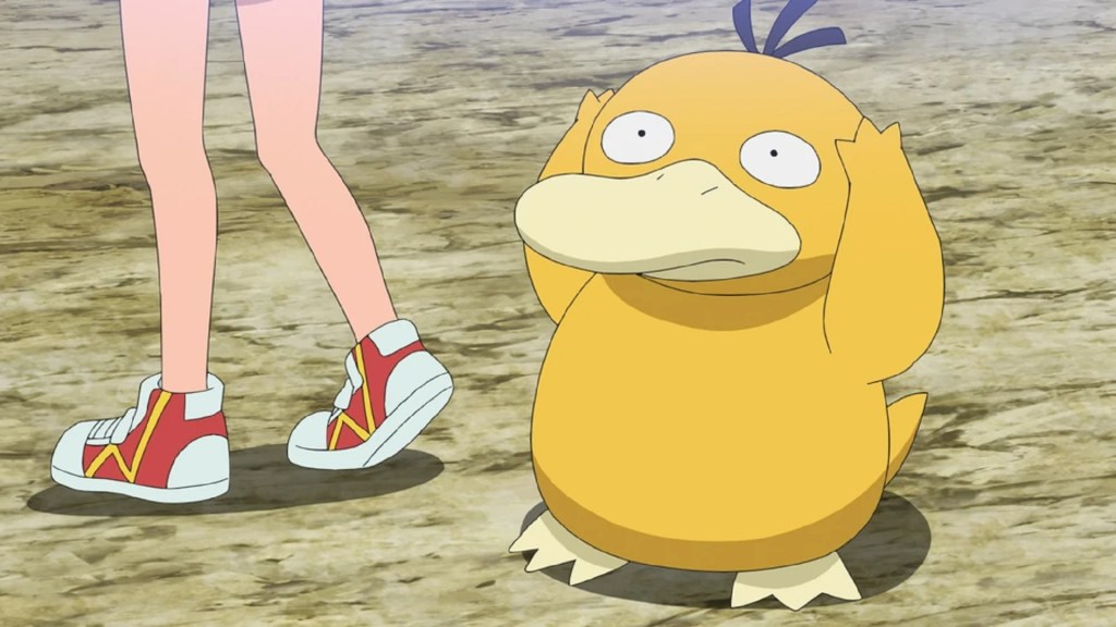 L'image montre le Pokémon Psycanard, un canard rond de couleur orange avec une expression anxieuse se tenant la tête.