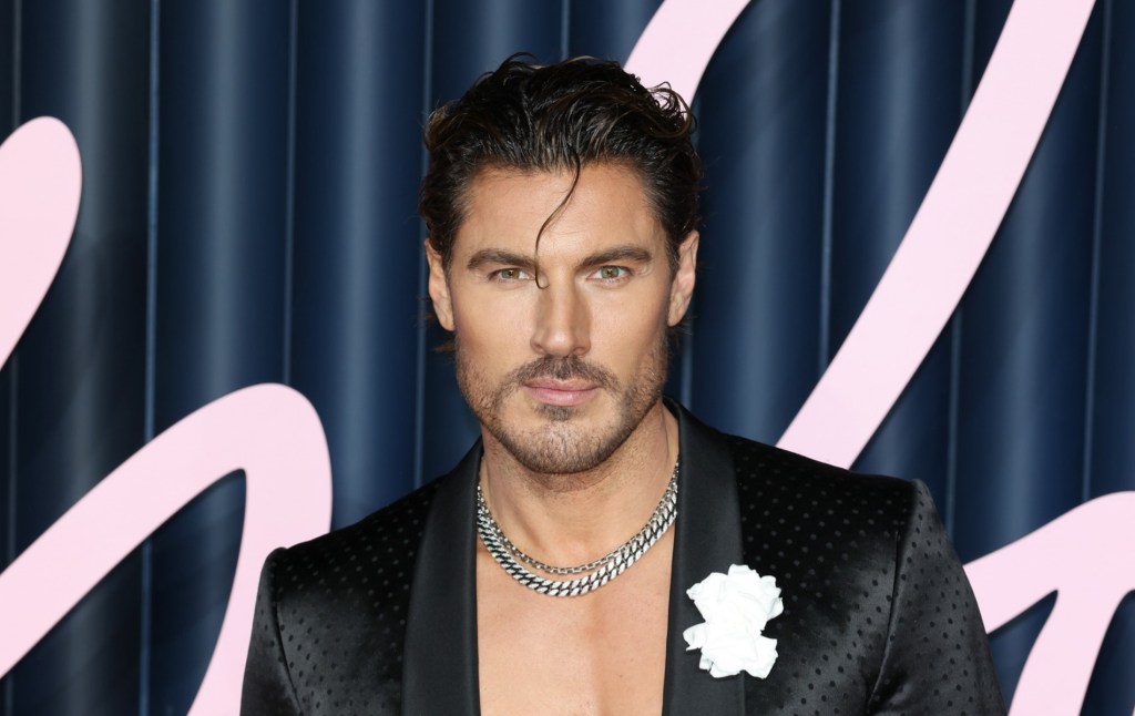Chris Appleton assiste aux Fashion Awards, torse nu mais vêtu d'un blazer noir, une mèche de cheveux sur son as